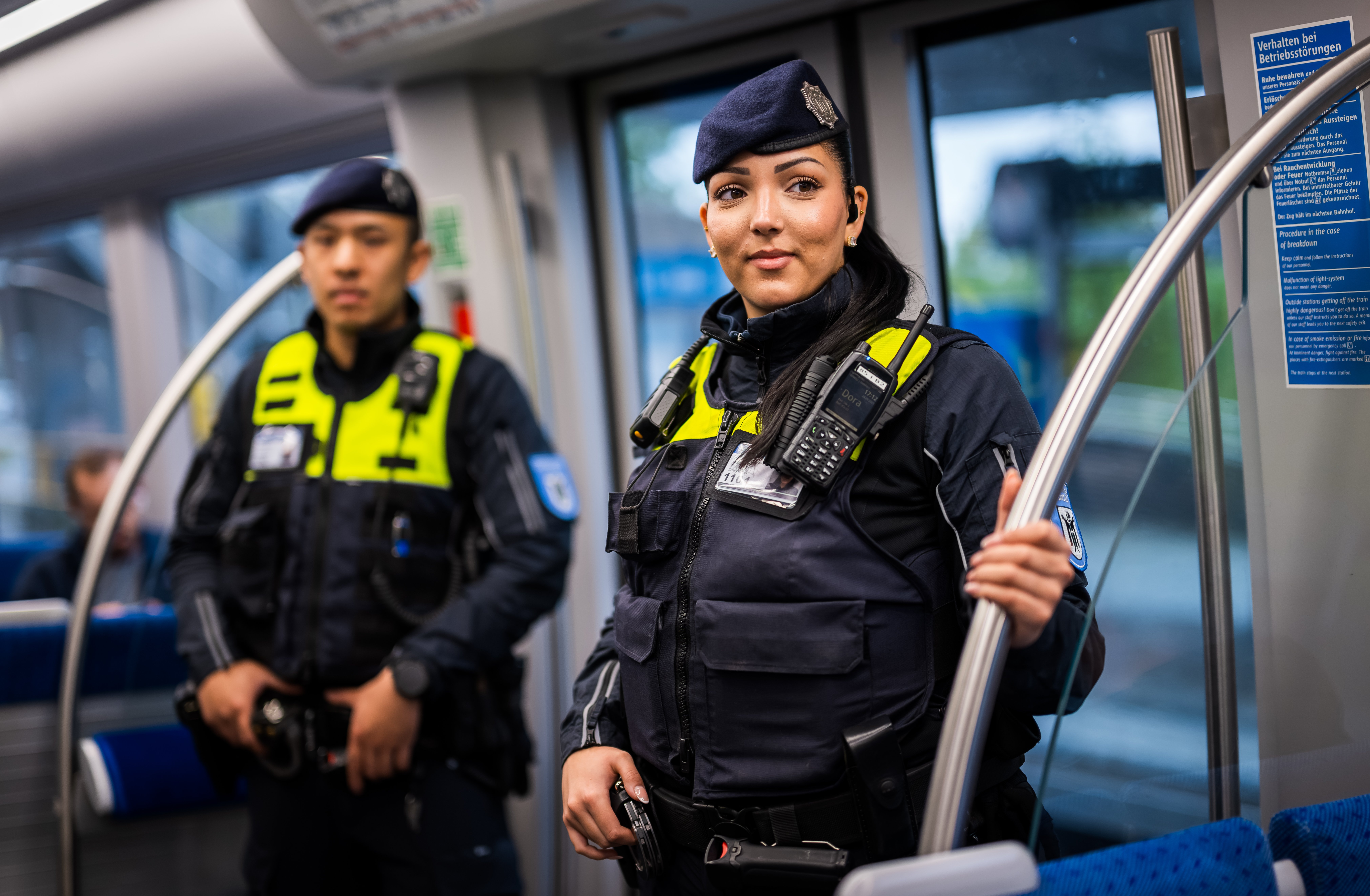 A female and a male Münchner U-Bahnwache guard in a train.